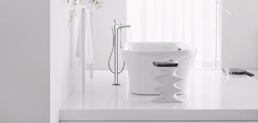 A freestanding bath tap next to a bath.